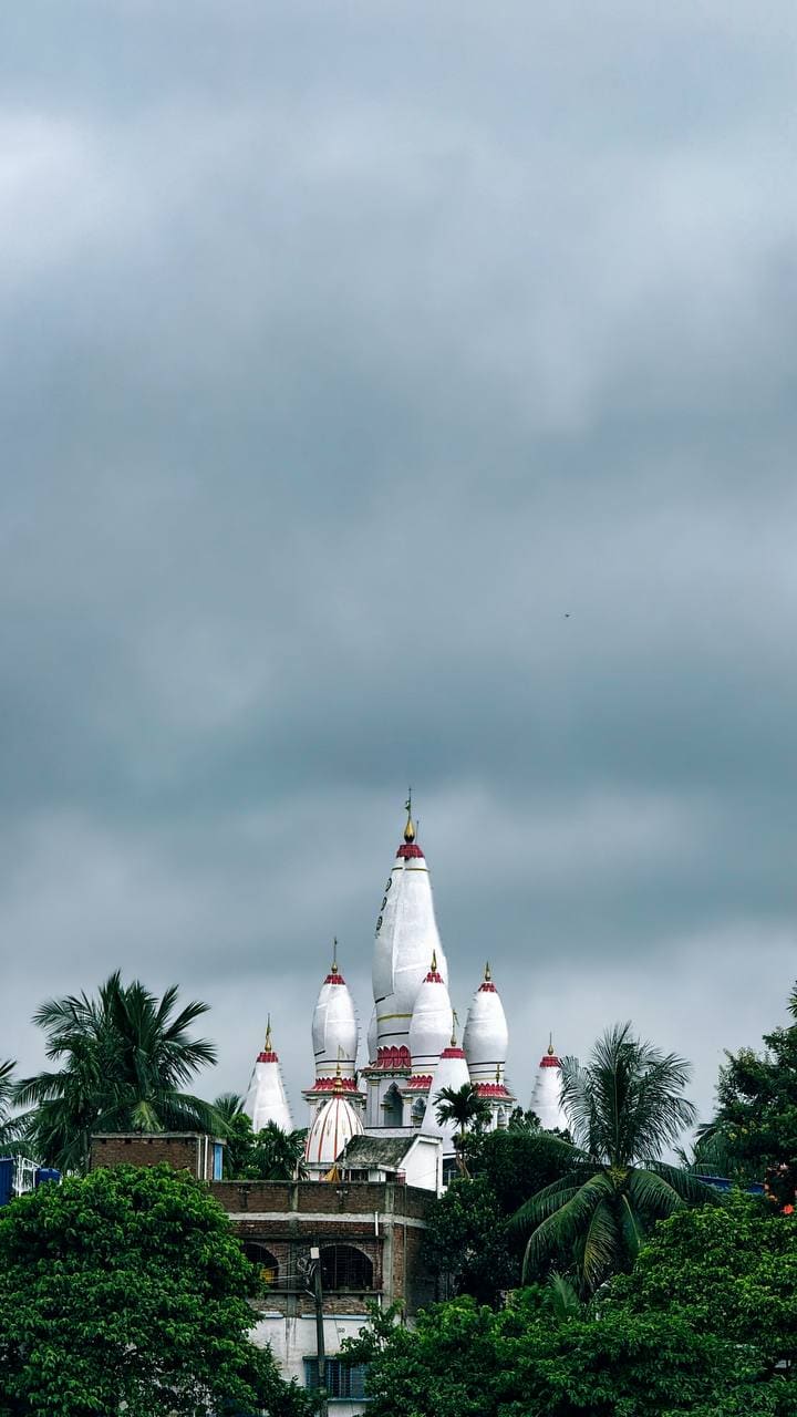 White temple spires rising above palm trees
